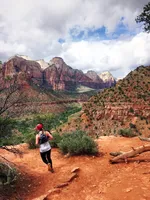 Girl running down the Zion mountains.